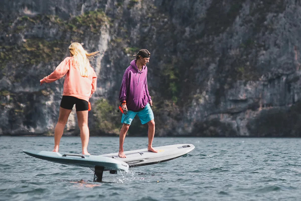Mand og pige står på elektrisk jetboard