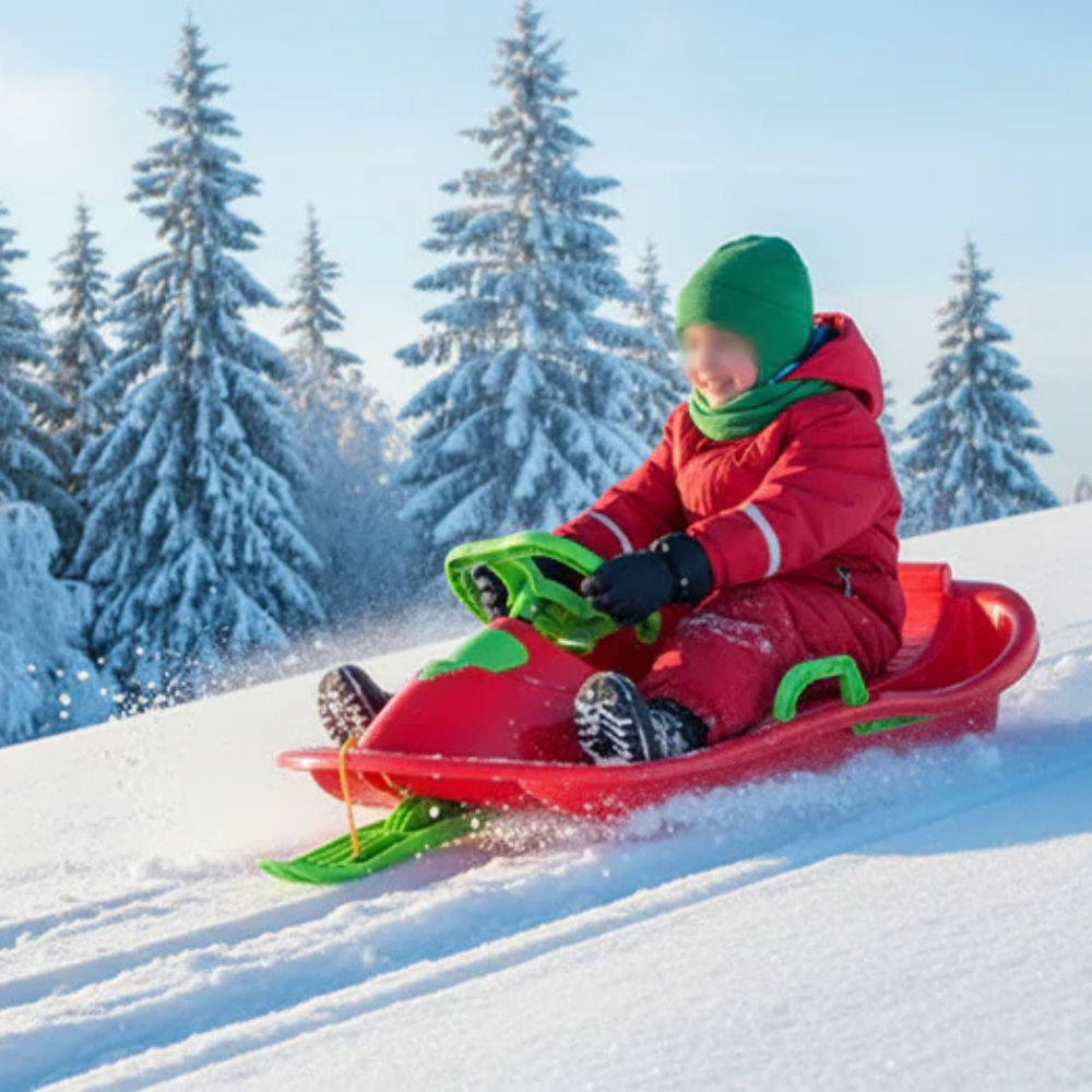 pige kører i snowrider bobslæde rød med rat i sne