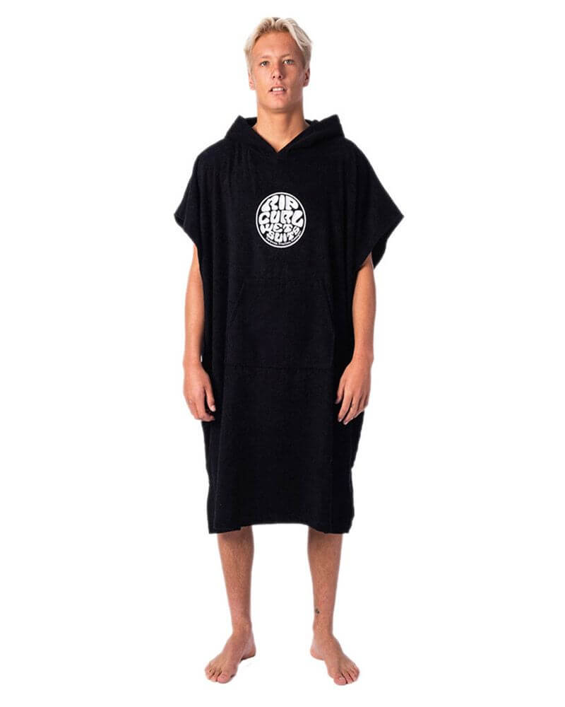 Mand med lyst hår iført en sort badeponcho med et hvidt logo på fronten, hvor der står Rip Curl
